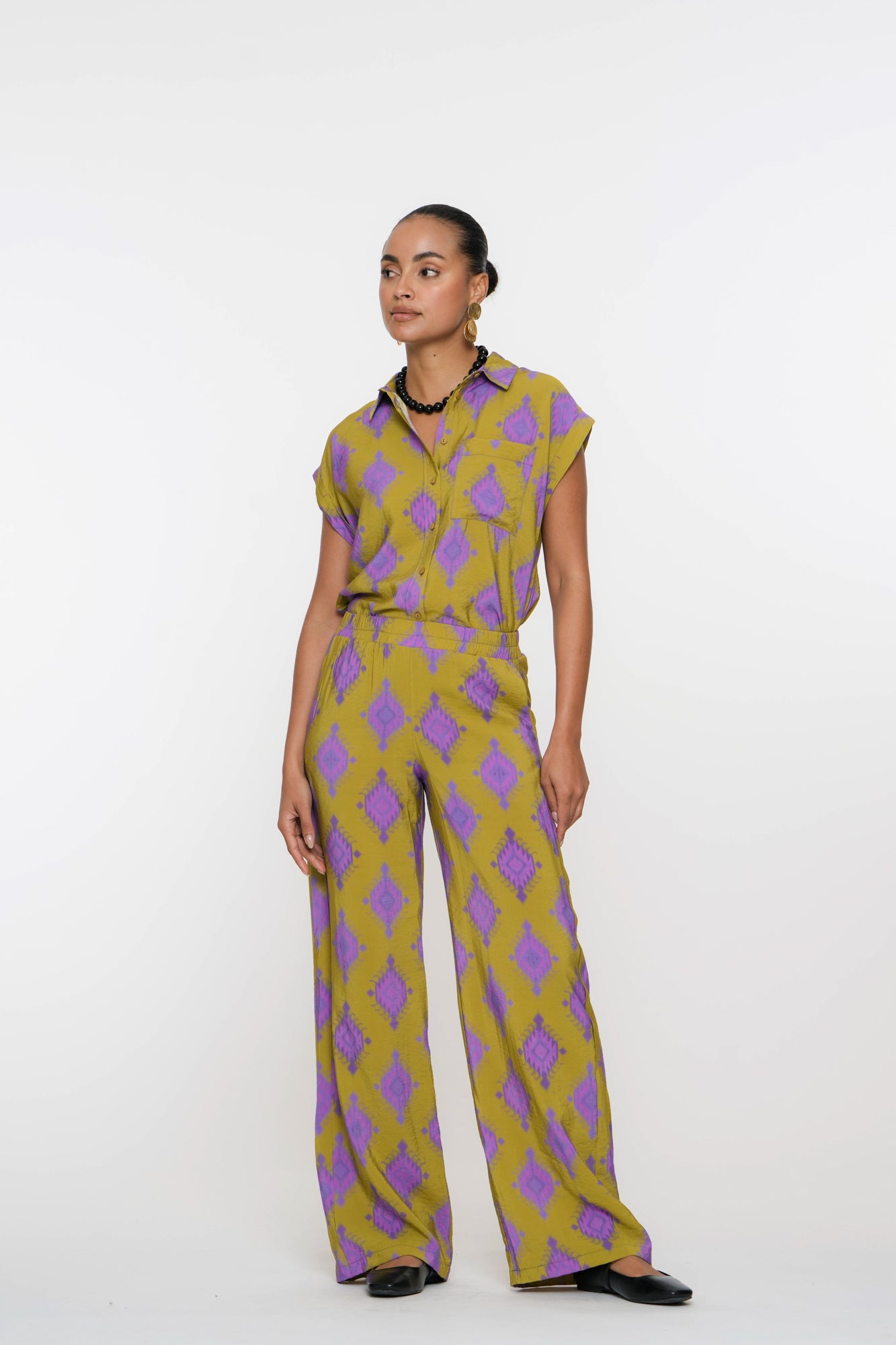 Geisha Fashion shirt, buttoned with geometric patterns, against white.
